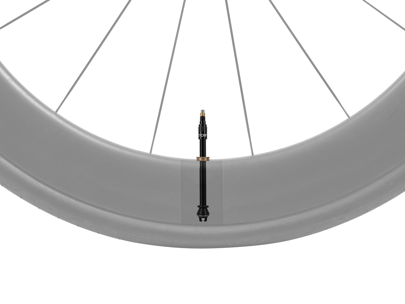 Schwarzes Tubeless-Ventil mit goldfarbener Rändelmutter montiert in einem grauen Fahrradlaufrad mit Speichen, auf weißem Hintergrund.