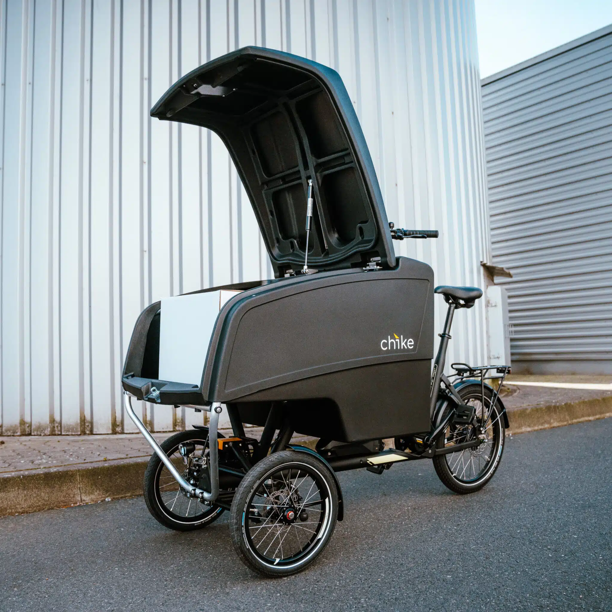 chike E‑Cargo Pro Lastenrad in Schwarz mit geoeffnetem Laderaum und weisser Box.