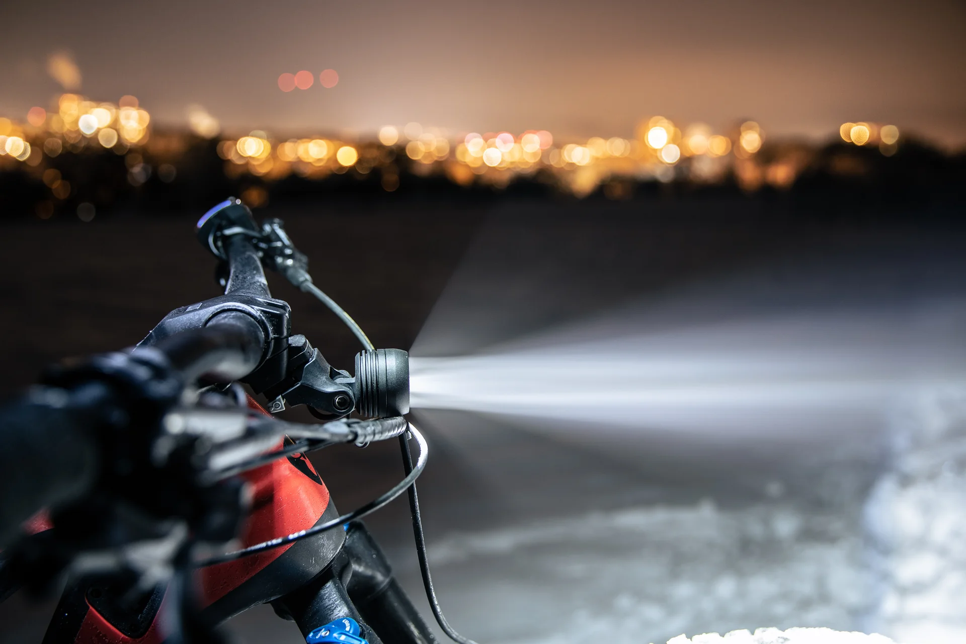 Feu avant Supernova Mini 3 Pro MonkeyLink, en usage réel de nuit sur vélo, vue de côté avec faisceau lumineux