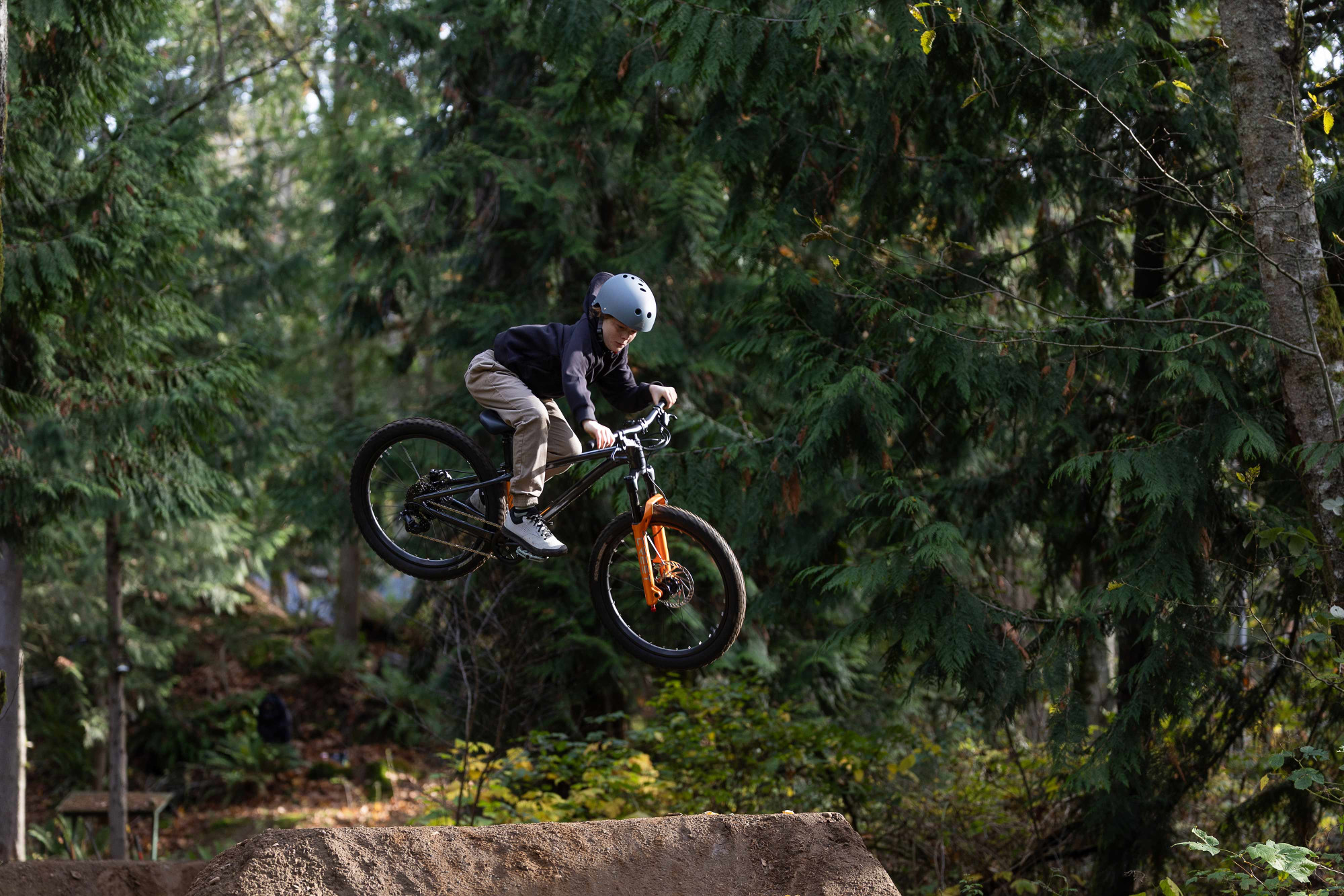 VTT semi-rigide dirt 24 pouces Giant STP 24, action en forêt en plein saut