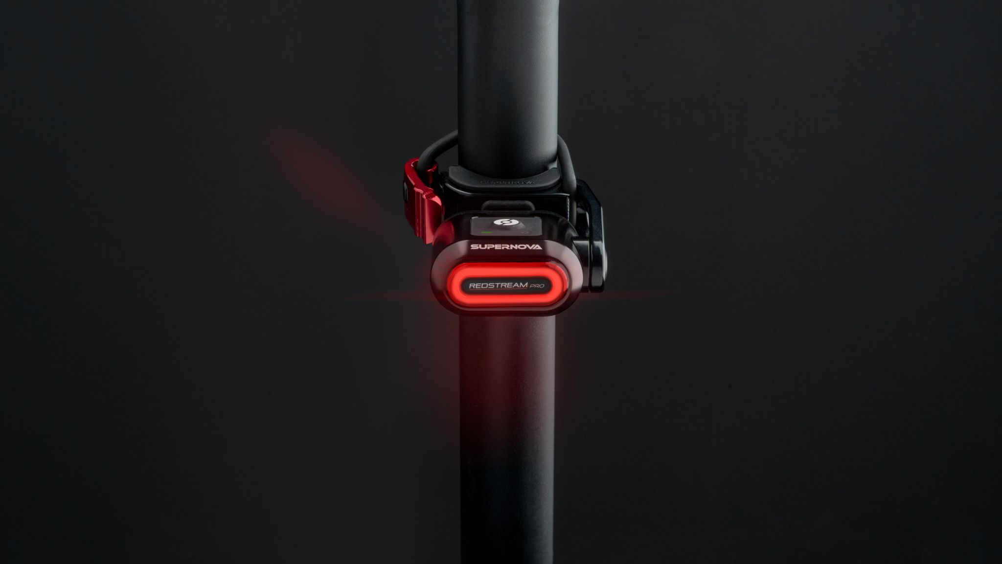Supernova Redstream Pro Ruecklicht in Schwarz an der Sattelstuetze mit rundem rotem LED-Licht.