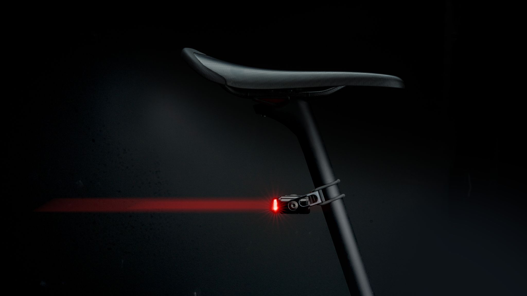 Supernova Redstream Pro Ruecklicht in Schwarz montiert an Satteltasche mit rotem LED-Ring.